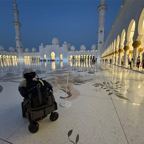 Person in power wheelchair visiting a mosque courtyard<br />
